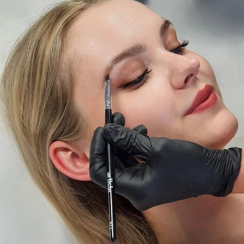 Klientka w czasie wykonywanego zabiegu makijażu permanentnego brwi